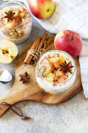 Photo for Homemade dessert with yogurt, granola, caramel apples and cinnamon on a stone table. Healthy breakfast granola, healthy lifestyle. - Royalty Free Image