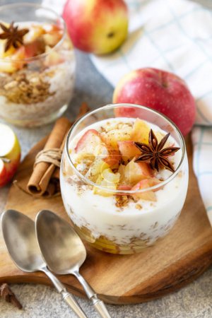 Photo for Healthy breakfast granola, healthy lifestyle. Homemade dessert with yogurt, granola, caramel apples and cinnamon on a stone table. - Royalty Free Image