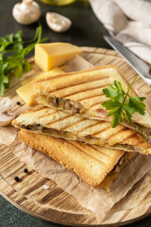 Téléchargez les photos : Délicieux sandwich au fromage grillé, bacon et champignons. Petit déjeuner fait maison sur une table en pierre sombre. - en image libre de droit