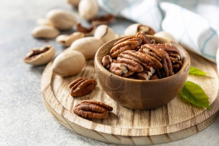Photo for Bowl with pecan nuts on a stone table. Nuts and seeds, healthy fats, various trace elements and vitamins. Copy space. - Royalty Free Image