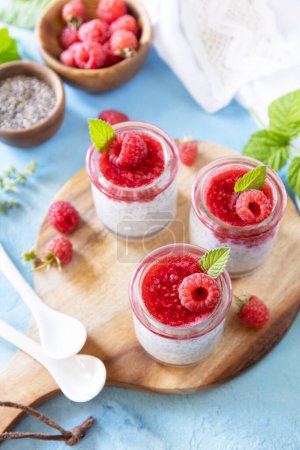 Photo for Chia seed pudding with raspberry and jam or smoothies with chia seeds on a stone table. Healthy breakfast. Copy space. - Royalty Free Image