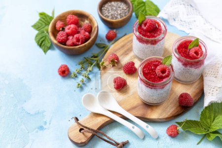 Photo for Healthy breakfast. Chia seed pudding with raspberry and jam or smoothies with chia seeds on a stone table. Copy space. - Royalty Free Image