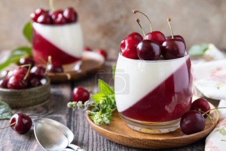 Photo for Panna cotta with sweet cherry jelly on a rustic table. Italian dessert, homemade cuisine. Copy space. - Royalty Free Image