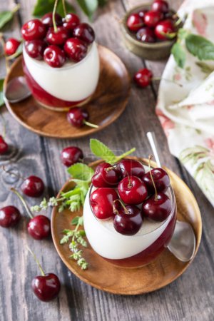 Panna cotta with sweet cherry jelly on a rustic table. Italian dessert, homemade cuisine.