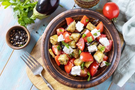 Téléchargez les photos : Une alimentation saine faible en glucides. Salade avec aubergines grillées, tomates et fromage feta sur une table rustique en bois. Vue d'en haut. - en image libre de droit