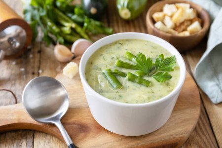 Foto de Puré de sopa vegana de verduras verdes. Cuenco de frijol verde y sopa de crema de calabacín en una mesa rústica. Dieta saludable baja en carbohidratos. - Imagen libre de derechos