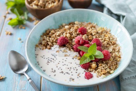 Photo for Diet nutrition concept. Healthy breakfast cereal bowl homemade granola with fresh raspberry and chia seeds on a rustic table. - Royalty Free Image