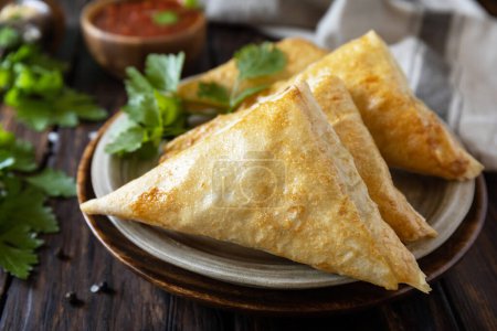 Photo for Asian food. Vegetarian samsa (samosas) with tomato sauce on a wooden table. Popular in Indonesia as Risoles Sayur. - Royalty Free Image