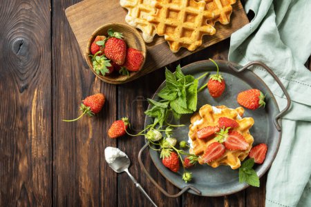 Photo for Belgian waffles with fresh berrie strawberries and ricotta cheese for breakfast on a rustic table. View from above. Copy space. - Royalty Free Image