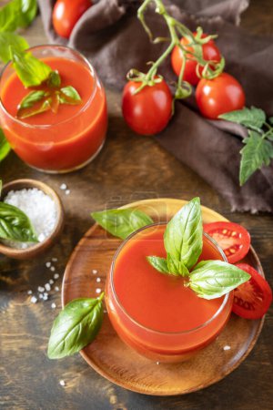 Foto de Vasos de jugo de tomate fresco con tomates, sal en la mesa de madera. Bebida de tomate vegetal para una dieta saludable. - Imagen libre de derechos