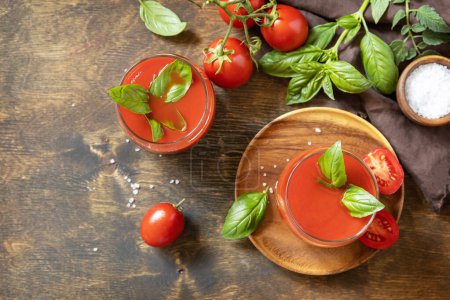 Foto de Vasos de jugo de tomate fresco con tomates, sal en la mesa de madera. Bebida de tomate vegetal para una dieta saludable. Vista desde arriba. Copiar espacio. - Imagen libre de derechos