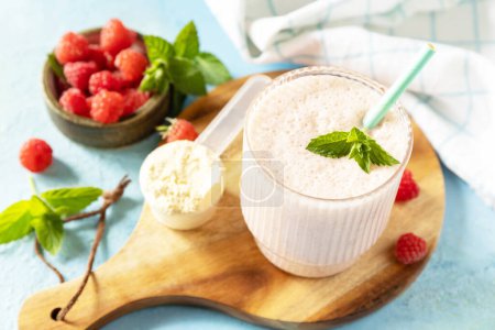 Photo for Protein shake with fresh berries. Fresh milk, raspberries drink on wooden board on a stone background. - Royalty Free Image