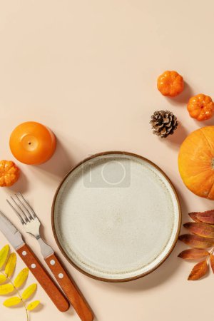 Photo for Autumn Halloween or Thanksgiving day table setting. Autumn background with an empty plate, cutlery, pumpkins. Thanksgiving background mock up. View from above. Copy space. - Royalty Free Image