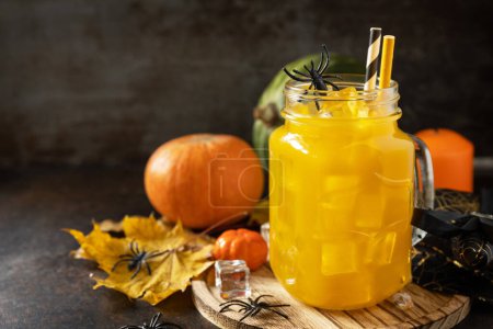 Photo for Halloween pumpkin iced cocktails in glass jars on a stone table. Party cocktails. Copy space. - Royalty Free Image