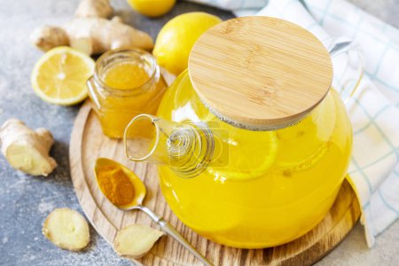 Téléchargez les photos : Thé au citron curcuma antioxydant au gingembre avec du miel sur une table en pierre. Boisson végétalienne biologique saine. Thé d'hiver, boisson stimulante pour l'immunité. - en image libre de droit