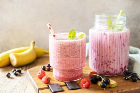 Photo for Raspberries, bananas and black currant. Set of fresh various delicious milkshakes or smoothies with fresh berries. Copy space. - Royalty Free Image
