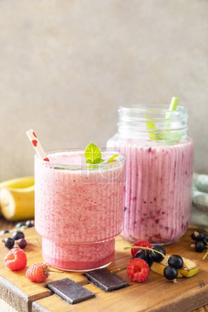 Photo for Set of fresh various delicious milkshakes or smoothies with fresh berries on a rustic background. Raspberries and black currant. Copy space. - Royalty Free Image