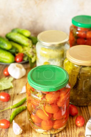 Photo for Salted pickled cucumbers and tomatoes preserved canned in glass jar. Home economics, autumn harvest preservation. Healthy homemade fermented food. - Royalty Free Image