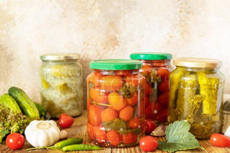 Photo for Healthy homemade fermented food. Salted pickled cucumbers and tomatoes preserved canned in glass jar. Home economics, autumn harvest preservation. Copy space. - Royalty Free Image