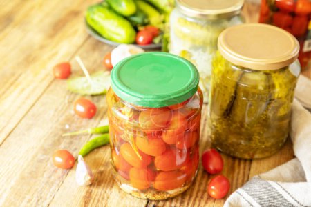 Photo for Salted pickled cucumbers and tomatoes preserved canned in glass jar. Home economics, autumn harvest preservation. Healthy homemade fermented food. Copy space. - Royalty Free Image