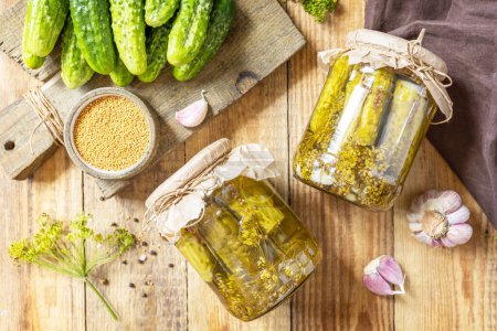 Photo for Healthy homemade fermented food. Salted pickled cucumbers with mustard preserved canned in glass jar. Home economics, autumn harvest preservation. View from above. - Royalty Free Image
