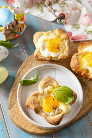 Foto de Huevos revueltos en hojaldre con queso y tocino. El desayuno de Pascua en la mesa de fiesta. - Imagen libre de derechos