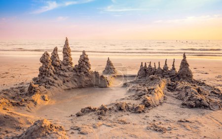 Téléchargez les photos : Sandcastle on the beach with warming light and beautiful sunset sky in summer vacation time - en image libre de droit