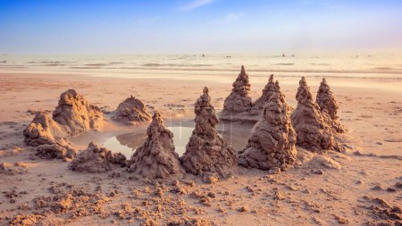 Foto de Sandcastle on the beach with warming light and beautiful sunset sky in summer vacation time - Imagen libre de derechos