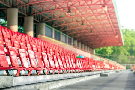 Téléchargez les photos : Rangée vide de chaises en plastique rouge sur le stade de sport pour remonter le moral du match de football - en image libre de droit