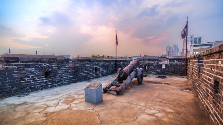 Téléchargez les photos : Anciens canons sur le mur de la forteresse de Hwaseong au crépuscule. Ce lieu historique est le célèbre patrimoine mondial de l'Unesco à Suwon, en Corée du Sud. - en image libre de droit