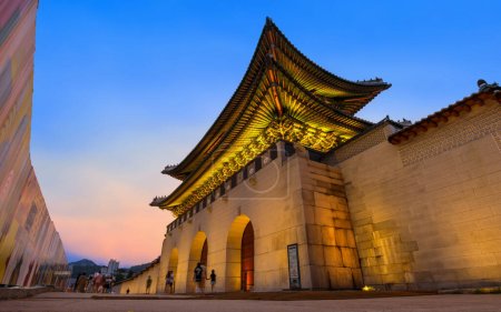 Téléchargez les photos : Surplombant un magnifique coucher de soleil, la porte de Gwanghwamun sert d'entrée principale au palais Gyeongbokgung et est la plus grande des portes situées sur son côté sud.. - en image libre de droit