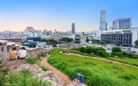 Téléchargez les photos : Séoul, Corée du Sud : 22 juillet 2023 : Coucher de soleil sur un paysage urbain animé avec le mur de Séoul, surplombant les bâtiments modernes, les rues et les piétons, mélangeant harmonieusement l'ancien et le nouveau - en image libre de droit