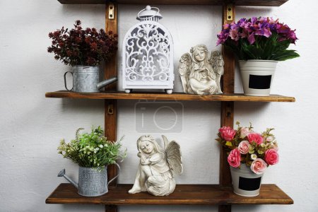 Photo for White lantern with ceramic dolls and artificial plant Interior home decoration on wooden shelf - Royalty Free Image