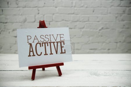 Téléchargez les photos : Passive Active text on white brick wall and wooden background - en image libre de droit