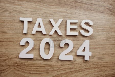 Taxes 2024 alphabet letters on wooden background