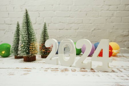 Happy New Year 2024 festive background with christmas tree on white brick wall background