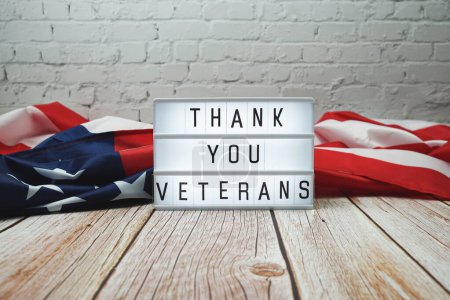 Danke Veteranen Wort in Leuchtkasten und amerikanische Flagge auf Holzgrund
