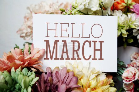 Hola mensaje de texto de marzo en la tarjeta de papel con hermosa decoración de flores
