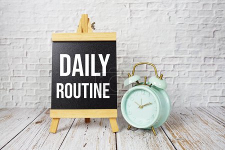 Daily Routine text message and alarm clock on wooden background