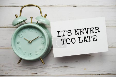 Photo for It's never too late text message with alarm clock top view on wooden background - Royalty Free Image