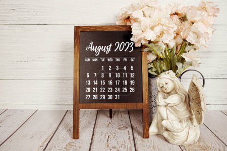 August 2023 monthly calendar on easel stand on wooden background