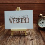 Have a nice weekend text on paper card on wooden background