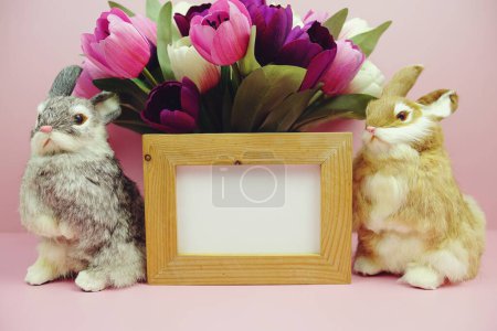 Easter Background decoration with rabbit doll and tulip flower bouquet on pink background