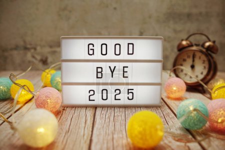 Photo for Goodbye 2025 text on lightbox on wooden background - Royalty Free Image