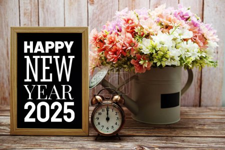 Photo for Happy New Year 2025 typography text on blackboard with alarm clock and flower in watering vase - Royalty Free Image