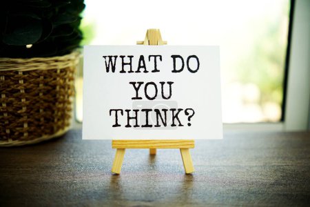 Photo for What do you think? text message on paper card with wooden easel - Royalty Free Image