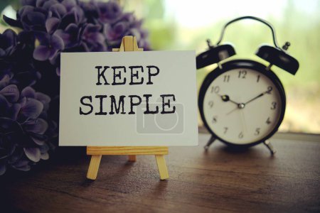 Keep simple text message text message on paper card with wooden easel on wooden table background, inspiration motivation concept