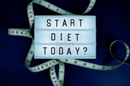 Start diet today? letterboard text on LED Lightbox and Measuring tape on blue background, Healthcare concept