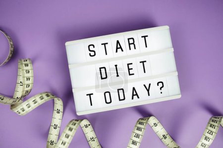 Start diet today? letterboard text on LED Lightbox and Measuring tape on purple background, Healthcare concept