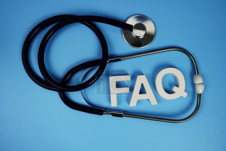 Photo for FAQ with wooden blocks alphabet letters and stethoscope on blue background - Royalty Free Image